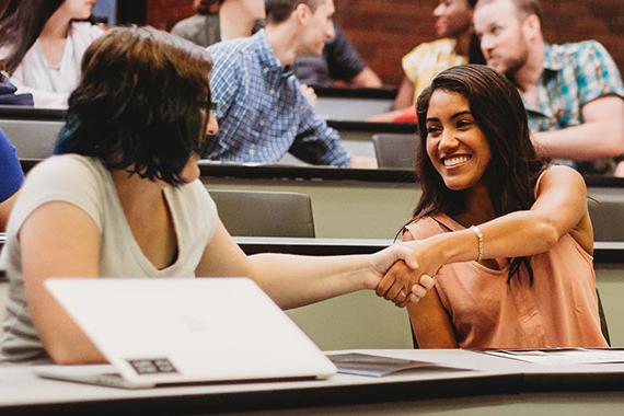 Graduate student shaking hands during orientation